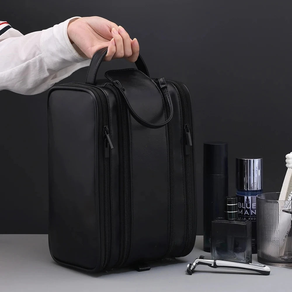A black PU leather travel toiletry bag with organizer pockets is being held by a hand.
