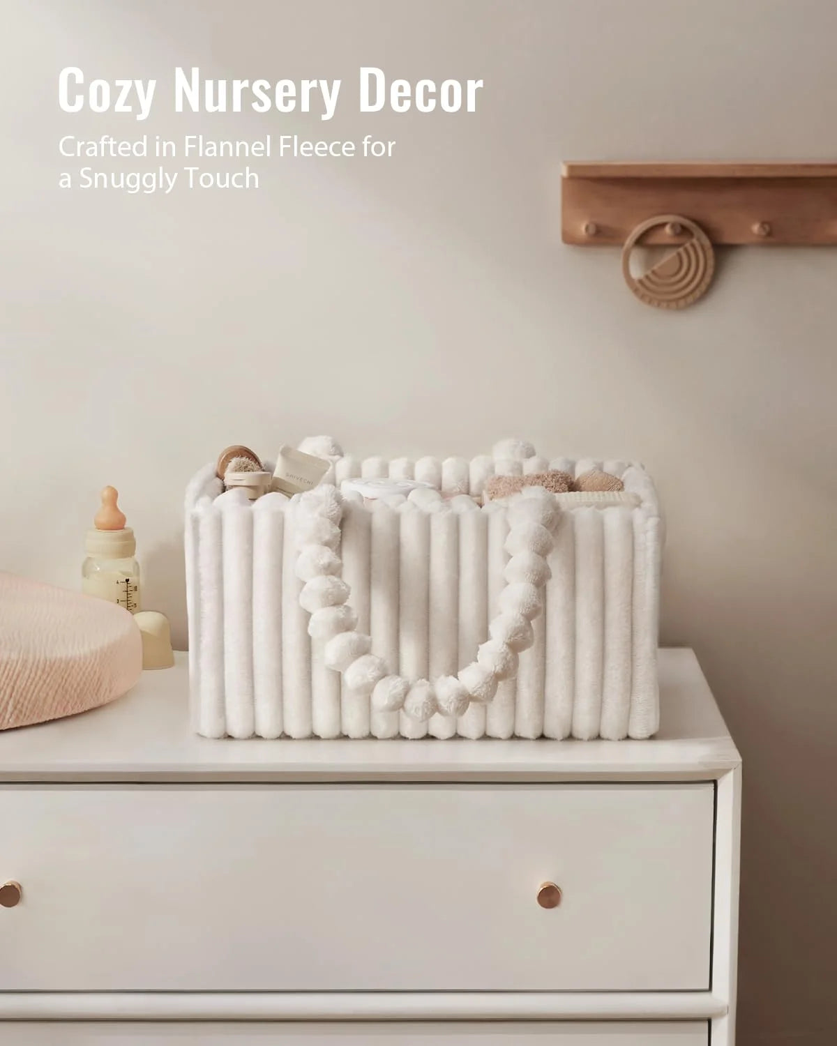 A white flannel diaper caddy organizer with a looped white trim is displayed on a light-colored dresser.