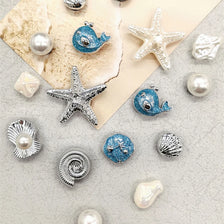 Silver and blue conch-shaped shoe charms and pearl beads displayed on a light background.