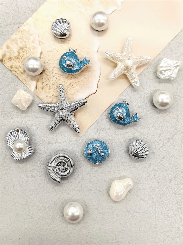 Silver and blue conch-shaped shoe charms and pearl beads displayed on a light background.