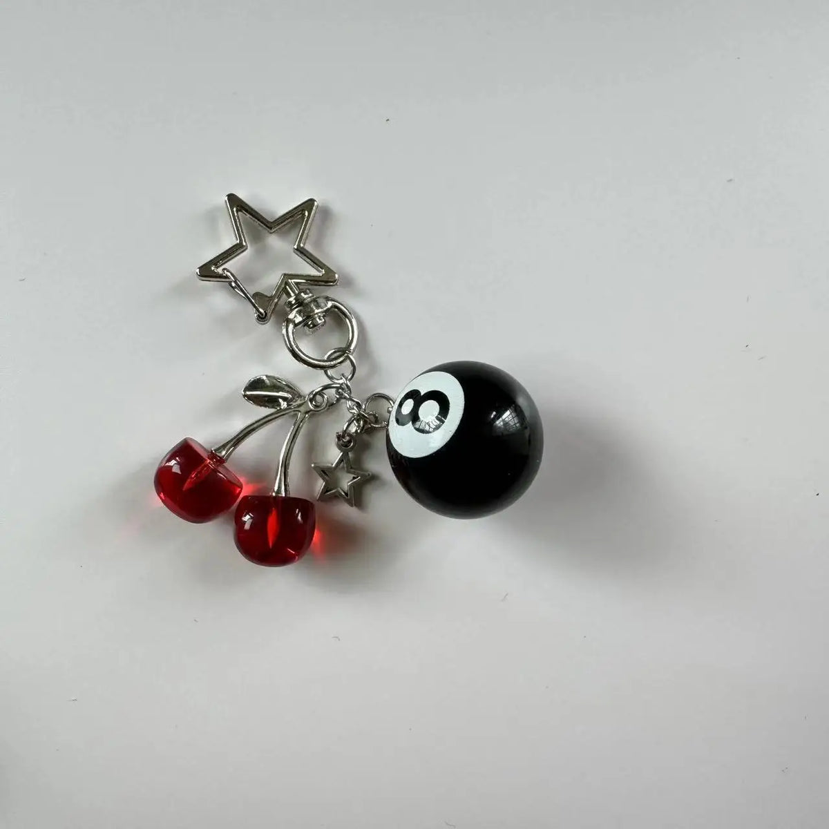 Silver Y2K 8 Ball keychain charm featuring a black ball and three red cherry balls.