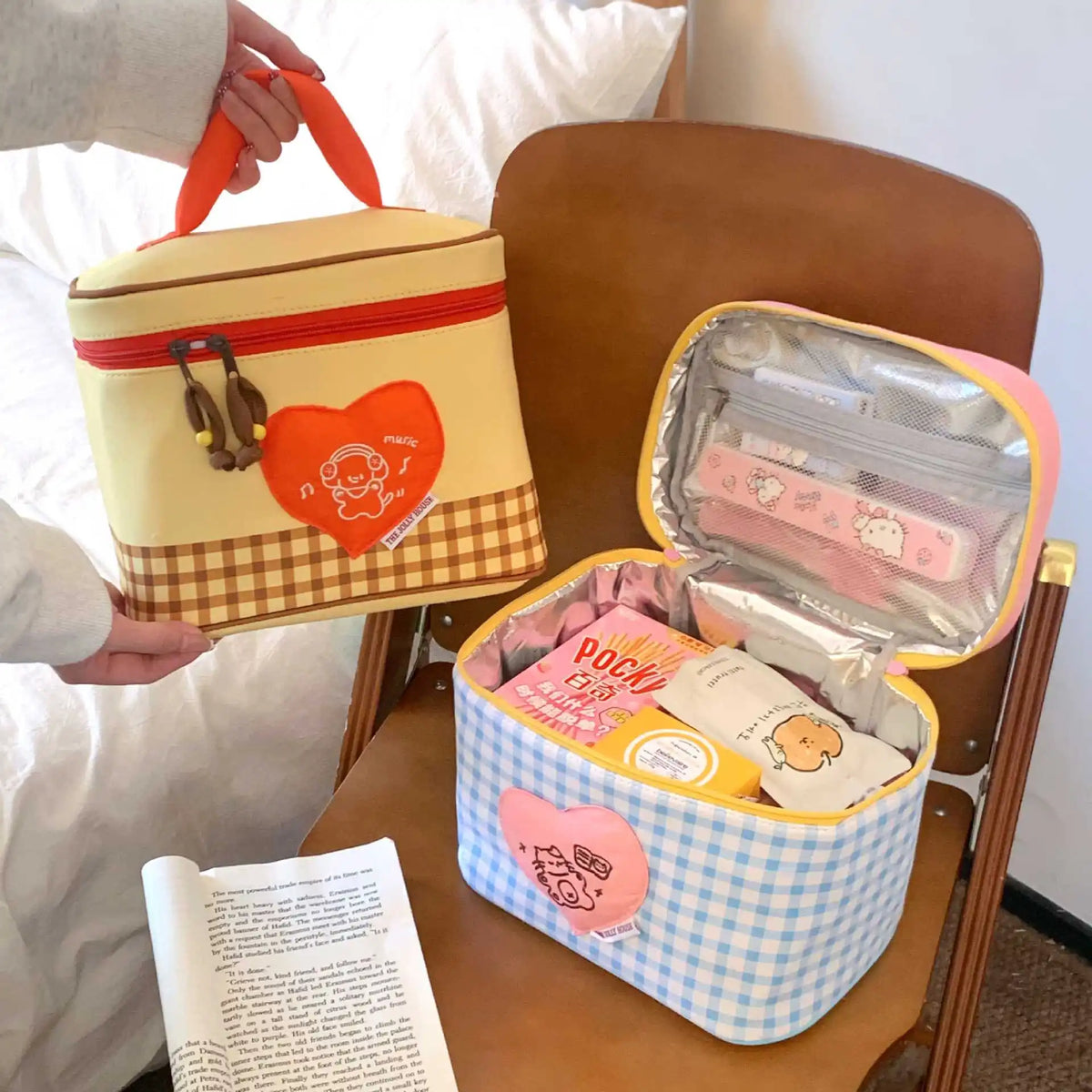 A yellow and brown cartoon insulated lunch bag is shown open, revealing pink and yellow food containers.