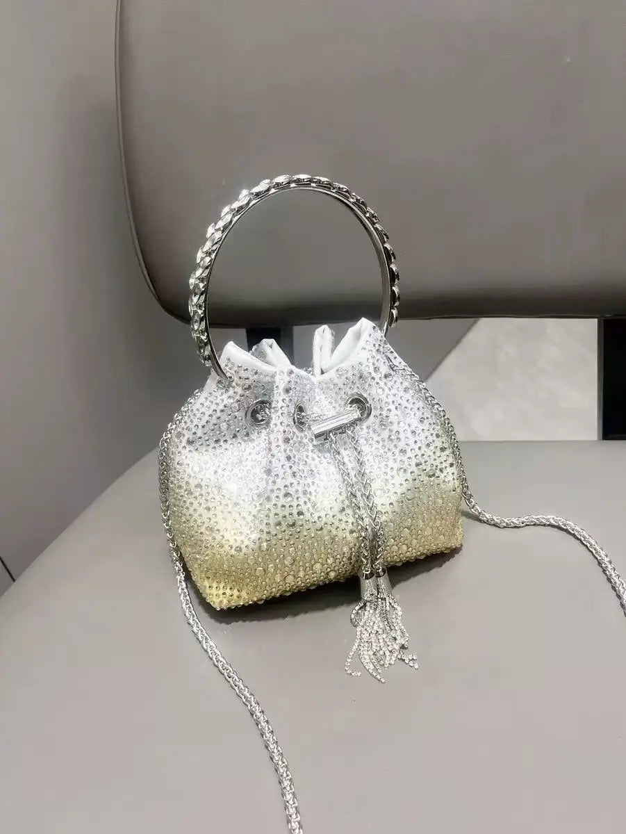 A small, pearlescent clutch bag embellished with crystals and featuring a silver chain strap.