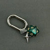 A silver keychain featuring a green resin die with the number 13 and a star charm.