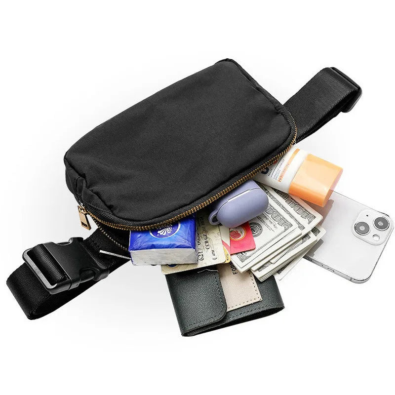Black waist bag or fanny pack with a strap, lying next to cash and a smartphone.