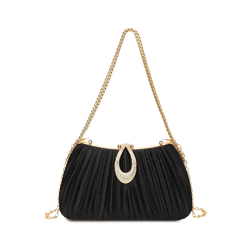 A black pleated evening clutch bag with a gold chain strap and a rhinestone pendant.