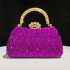 A vibrant magenta crystal-embellished evening clutch bag featuring a gold chain strap and crown embellishment.
