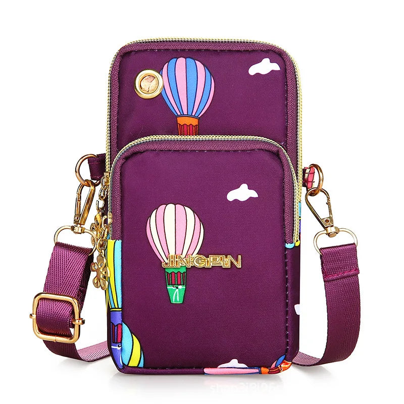 A purple waterproof nylon crossbody bag featuring a hot air balloon design and colorful accents.