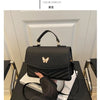 A black women's solid texture shoulder messenger bag is displayed on a dark surface.
