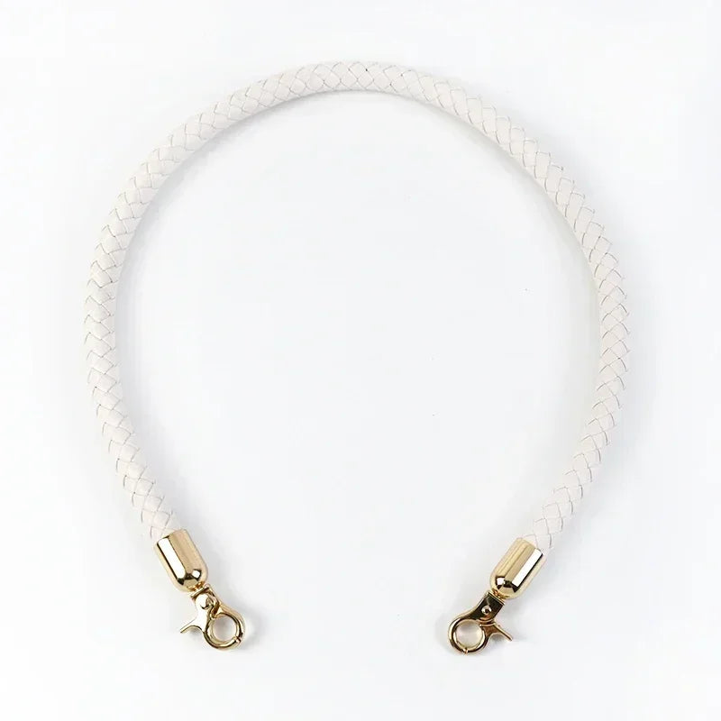 A white leather strap with gold metal buckles, used as replacement handles for a bag.