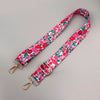 A pink and green floral pattern adjustable strap for a crossbody bag.