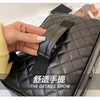 A close-up of a black quilted makeup storage pouch being held by a hand, highlighting the details.
