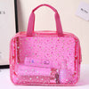 A pink clear waterproof makeup organizer bag filled with various cosmetic products and glittery stars.