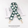 A dark green nylon strap with white flowers is displayed on a white background.