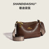 A brown luxury PU leather crossbody handbag with gold hardware and patterned strap.
