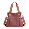 A mauve canvas tote bag with tan straps and zipper details.