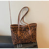 A brown leopard print vintage tote bag with leather handles displayed against a light background.