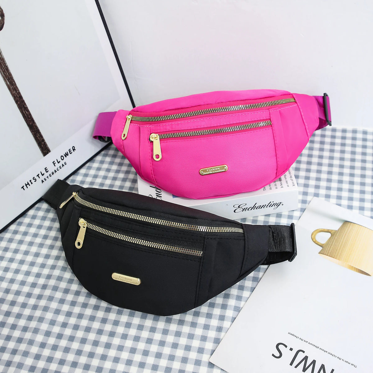 A pink lightweight nylon crossbody fanny pack is displayed next to a black one on a checkered surface.