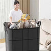 A black foldable non-woven storage bag filled with stuffed animals and a woman standing beside it.