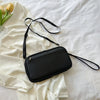 A black multi-functional passport and document organizer bag lying on a white fabric surface.