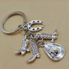 Silver keychain set featuring a cowboy boot, hat, and horseshoe charms.