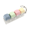 A clear plastic keyboard fidget toy with five pastel colored silicone keys arranged in a row.
