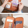 A brown leather RFID blocking travel passport holder is shown open, displaying various documents and cash.