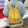 A yellow banana-shaped backpack worn by a person, displayed in a retail setting.