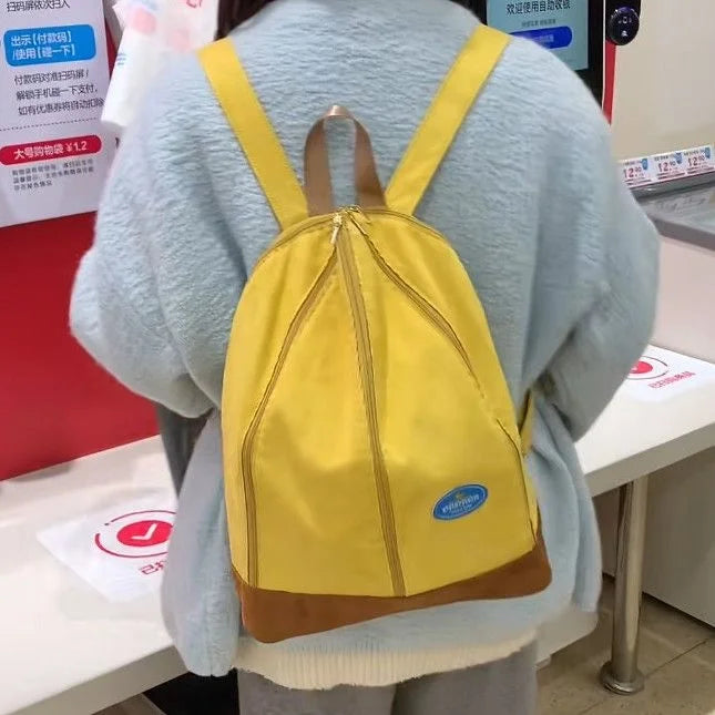 A yellow banana-shaped backpack worn by a person, displayed in a retail setting.