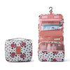 A pink multi-compartment travel pouch with a floral print and a hanging loop.