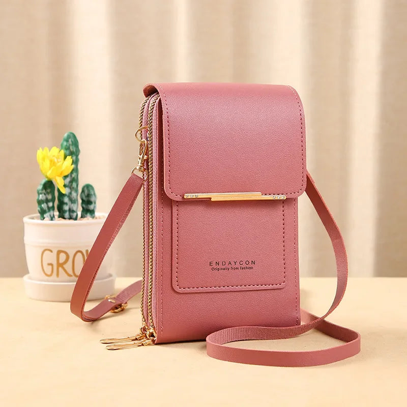 A pink leather luxury women's crossbody shoulder bag with gold hardware resting on a light surface.