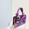 A purple sequin embroidered floral clutch bag with a purple strap displayed against a white background.