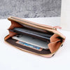 A tan leather crossbody cell phone bag with a zipper, open to show a smartphone inside.