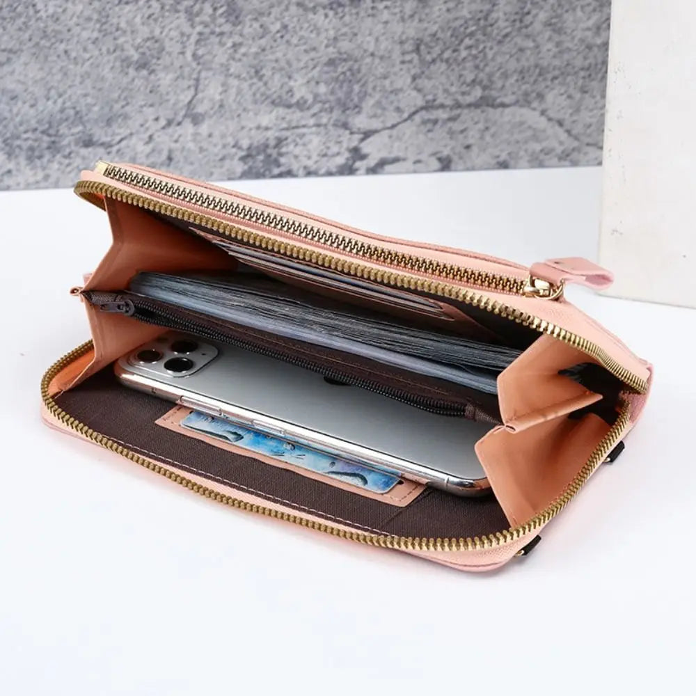 A tan leather crossbody cell phone bag with a zipper, open to show a smartphone inside.