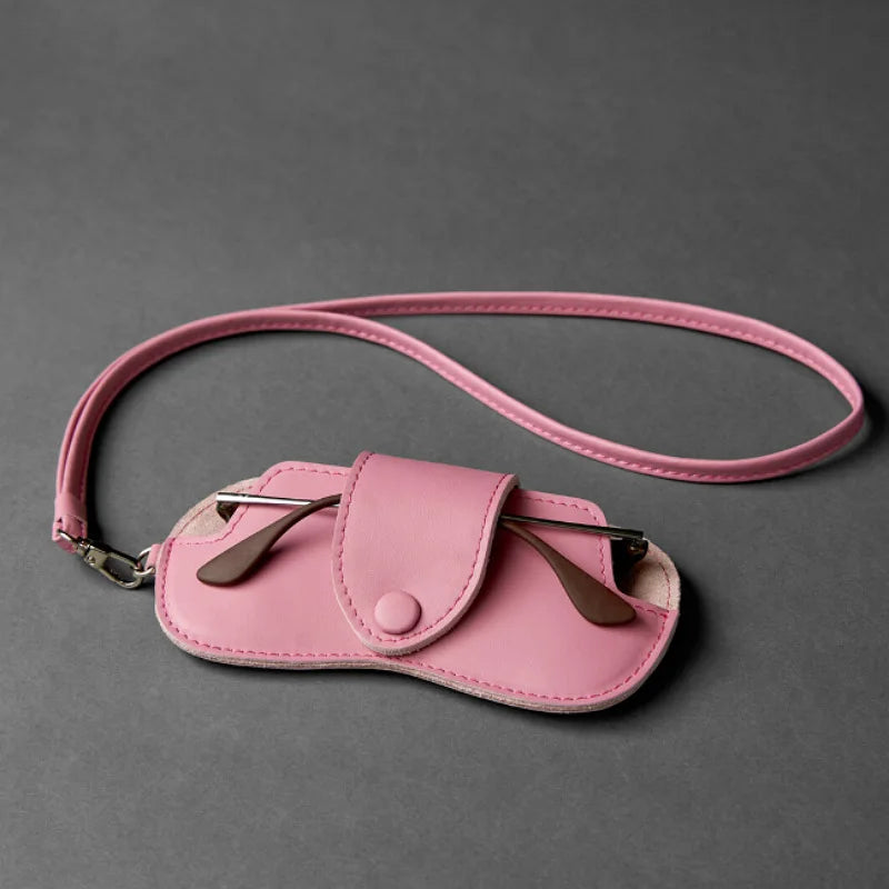 A pink PU leather storage case for eyewear, featuring a flap closure and leather ear pieces.