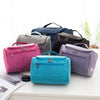 A collection of various colored portable Oxford cloth toiletry bags displayed on a white surface.