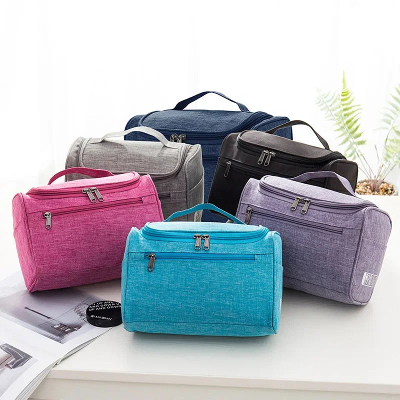 A collection of various colored portable Oxford cloth toiletry bags displayed on a white surface.