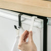 A hand is installing a heavy duty multi-purpose hook rack onto a white cabinet door using a white and black mounting system.