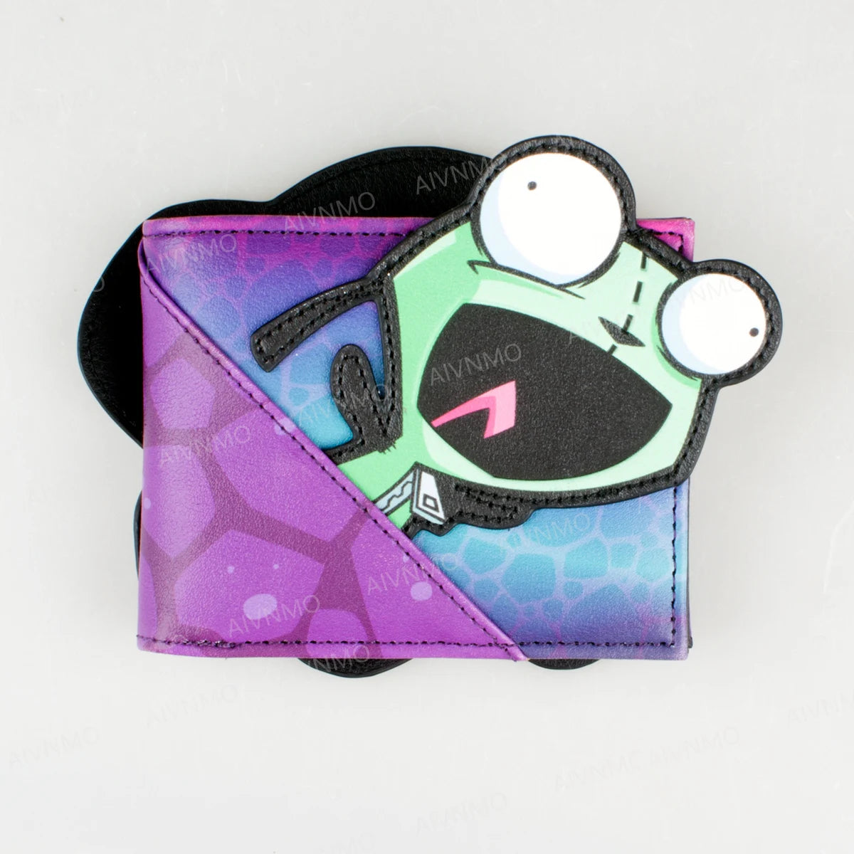 Cartera con soporte de tarjetas de impresión de caricatura con una criatura sonriente verde sobre fondo morado.
