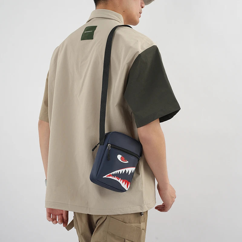 Une personne portant un haut beige à manche vert foncé et un porte-monnaie pour téléphone bleu marine en bandoulière.
