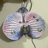 A realistic phalaenopsis orchid flower shaped keychain with purple and white petals.