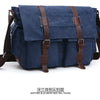 Navy blue canvas messenger bag with brown leather straps and pockets