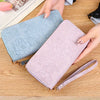 Dos carteras de tarjetas de cuero PU con relieve y flores en azul claro y rosa sobre una superficie de madera.
