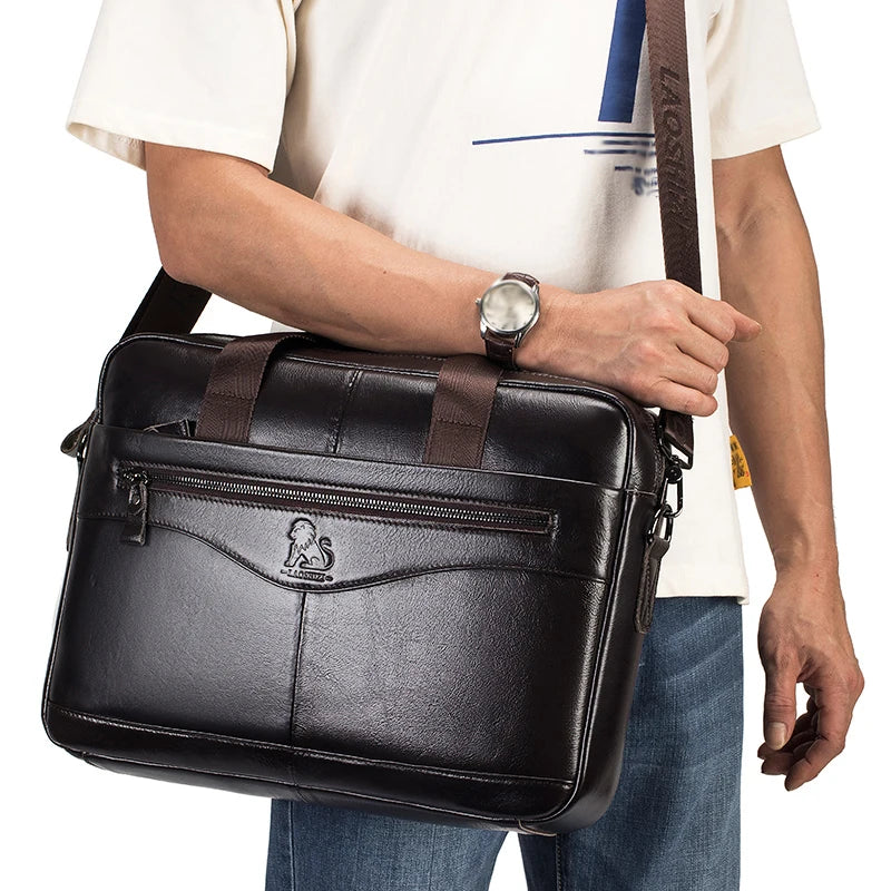 A person holds a black genuine cowhide leather briefcase bag against a white shirt.