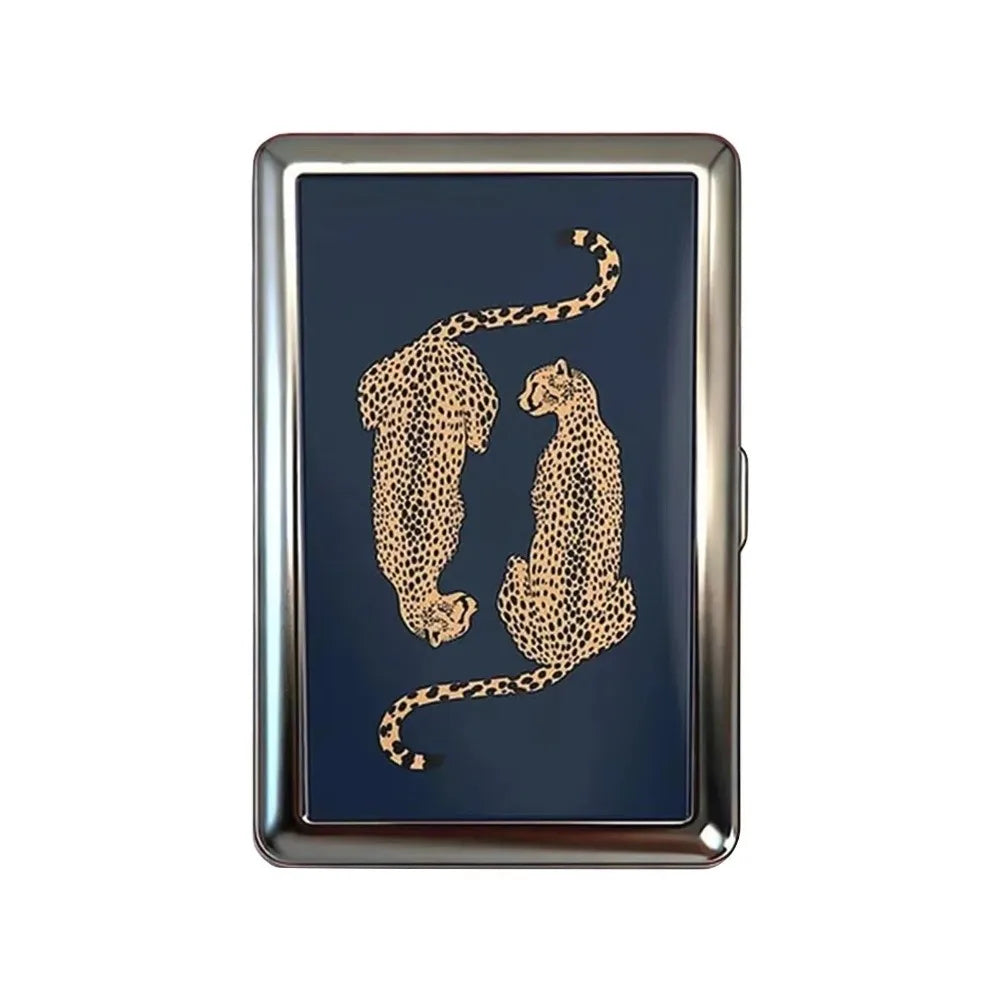 A vintage metal card holder with a dark blue surface featuring a gold leopard print silhouette.