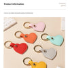 A collection of colorful leather heart keychains in pink, orange, red, green, and yellow displayed on a light background.