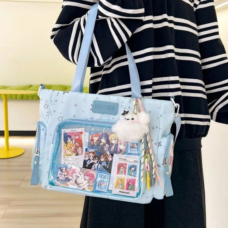 A light blue transparent shoulder tote bag featuring various ticket and photo cards with a fluffy white charm.