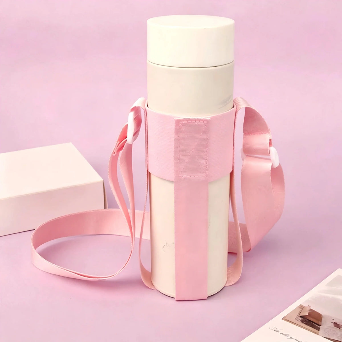 A pink crossbody sling water bottle bag with a white bottle and pink strap is displayed on a light purple background.
