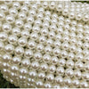A close-up view of a clutch bag covered entirely in small, round pearls.