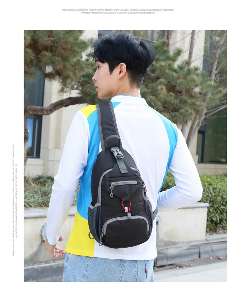 A young man wearing a white shirt and jeans is carrying a black nylon chest sling bag outdoors.